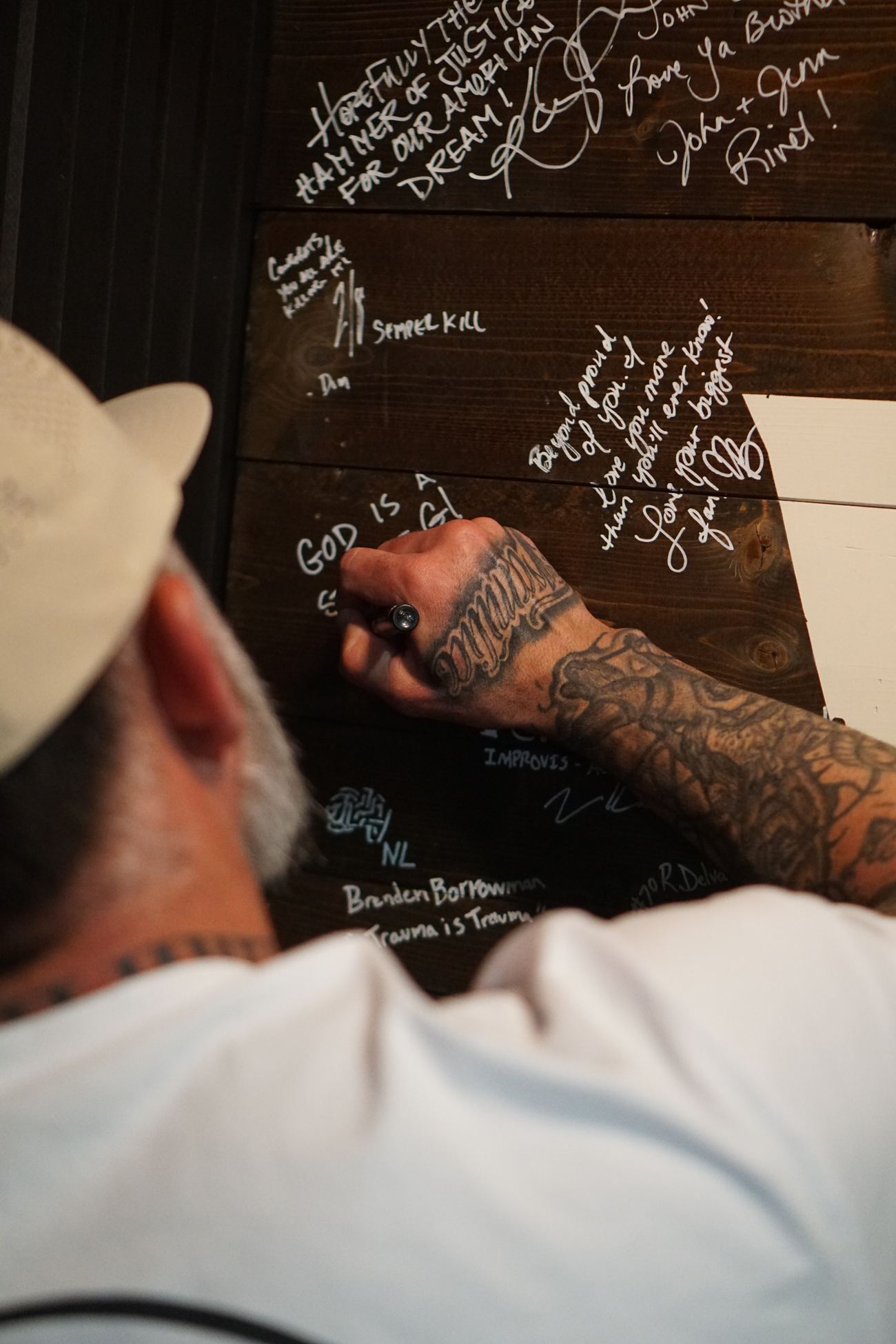 A guest signing the Wild Chaos wall up close